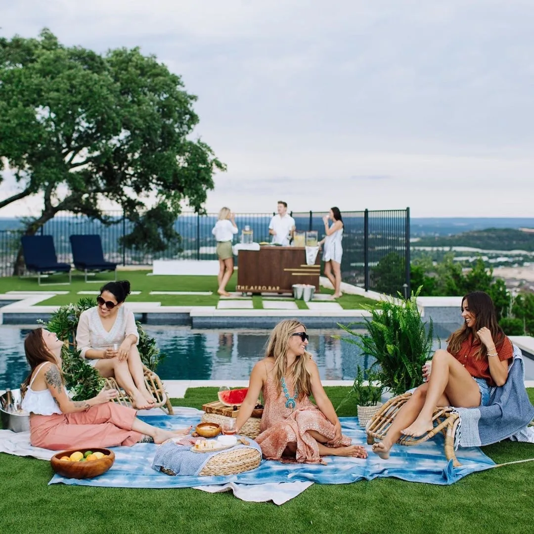 Group relaxing on a rooftop pool deck with artificial turf