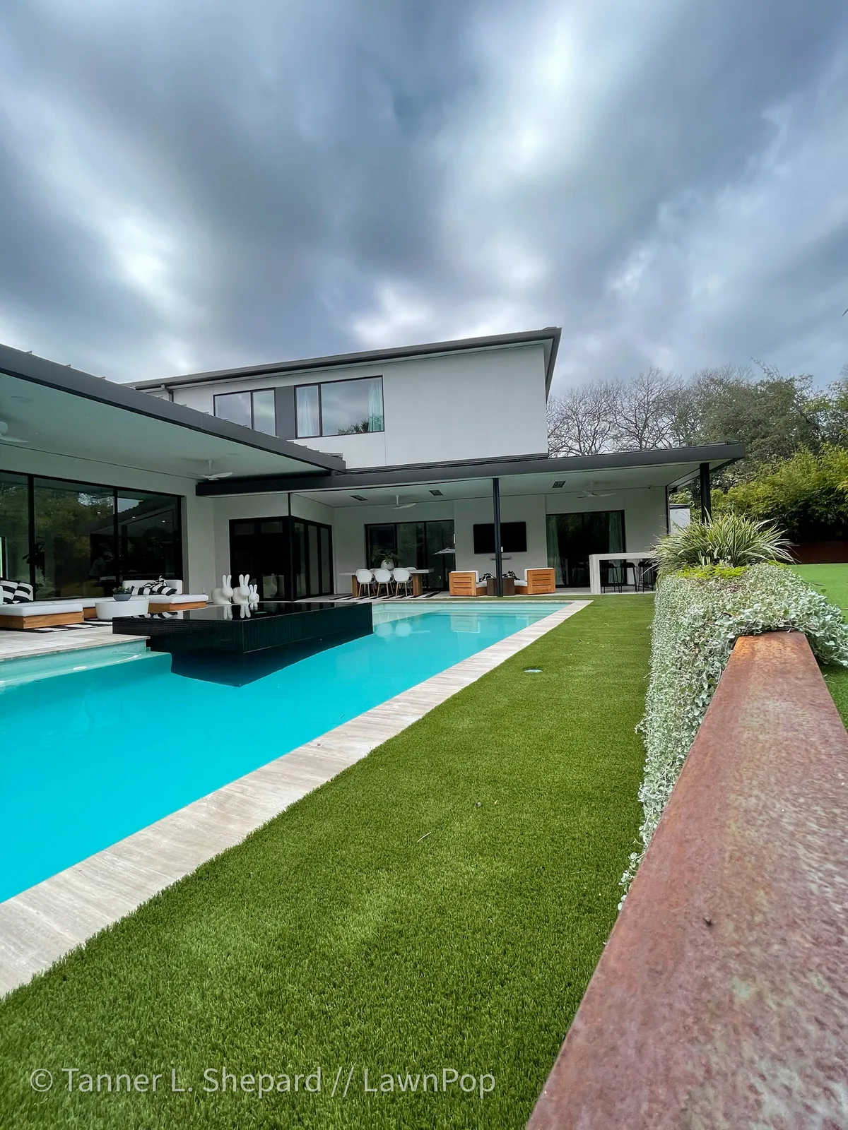 Modern home with a pool and artificial turf backyard
