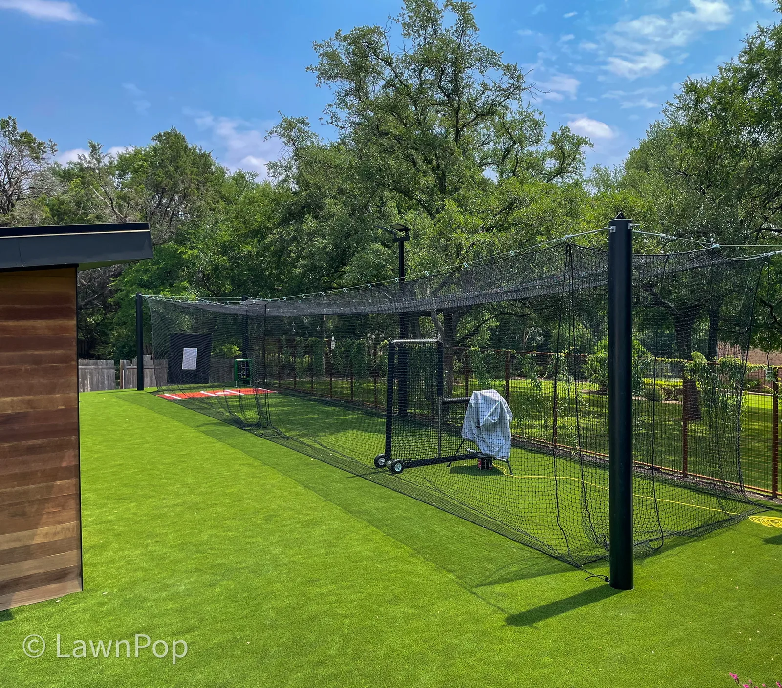 Backyard batting cage installed over artificial turf