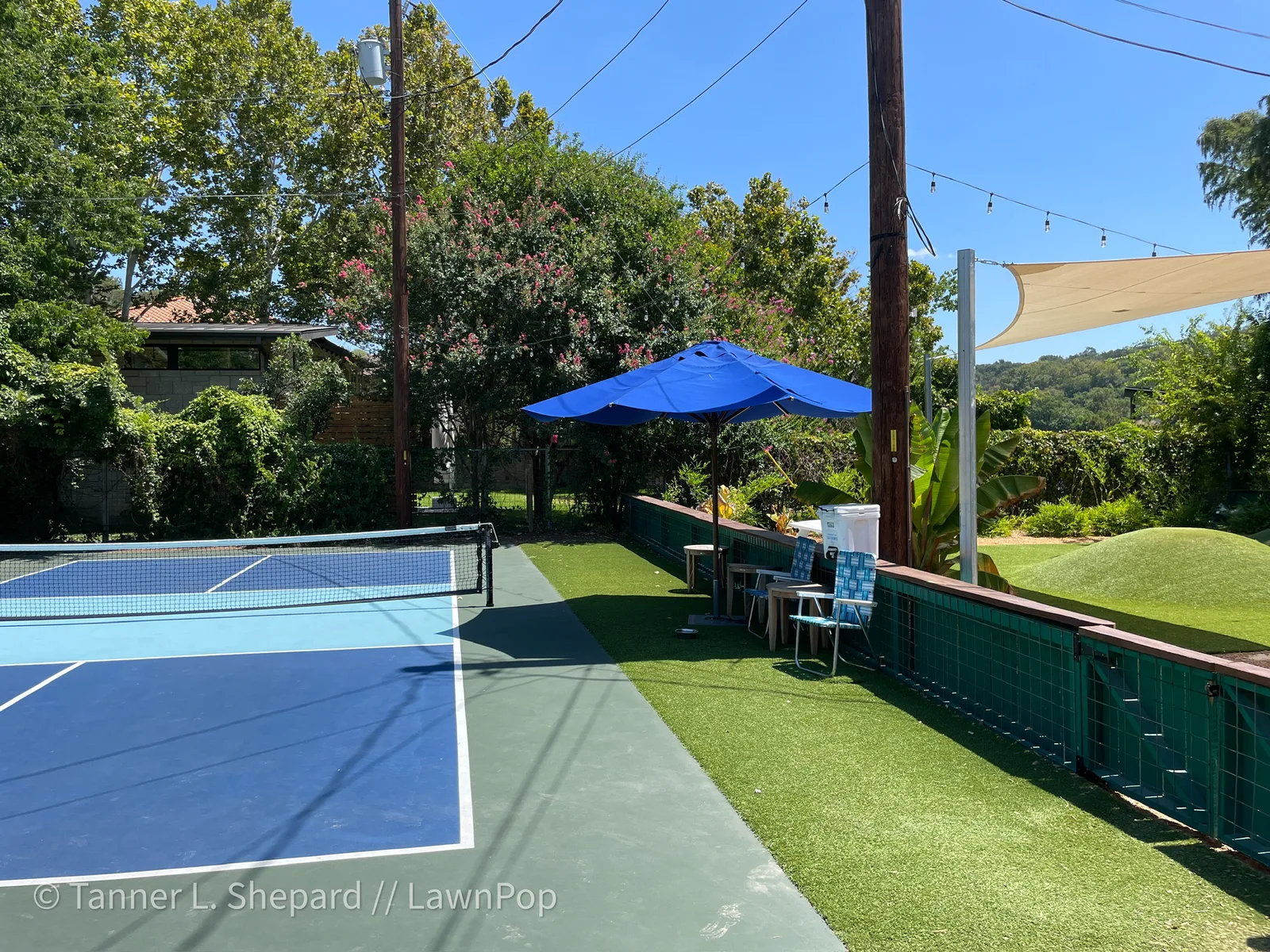 Blue sport court bordered by artificial grass